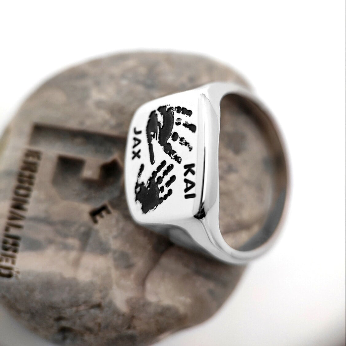 Silver signet ring back with engraved black handprints Jax and Kai