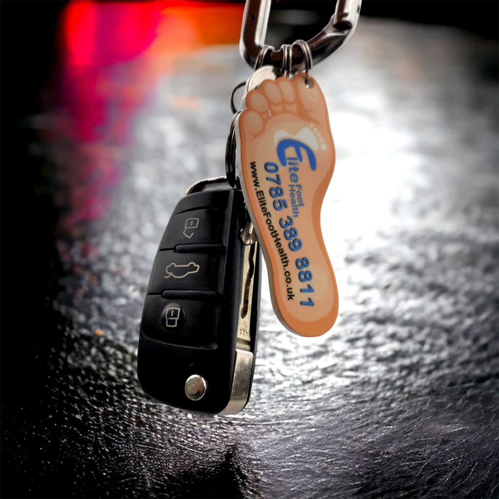 Orange foot-shaped keychain back with blue logo and contact info for podiatrists