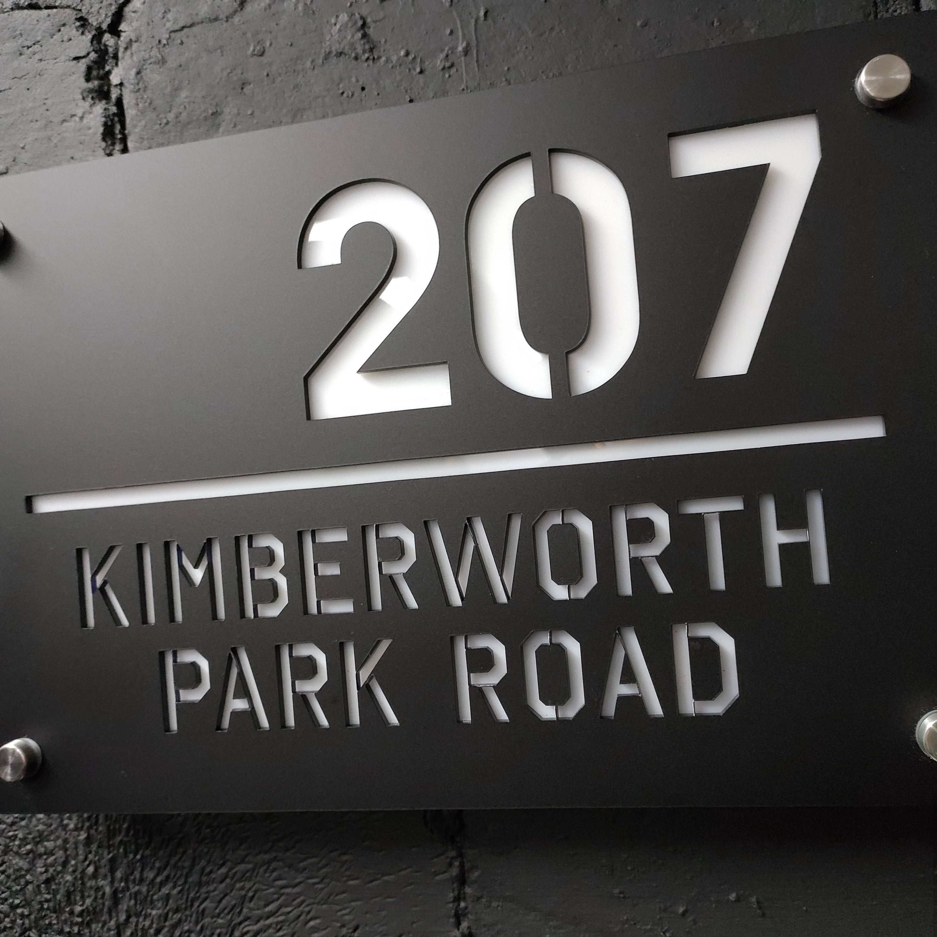 Black metal house sign with 207 numbers and Kimberworth Park Road engraving
