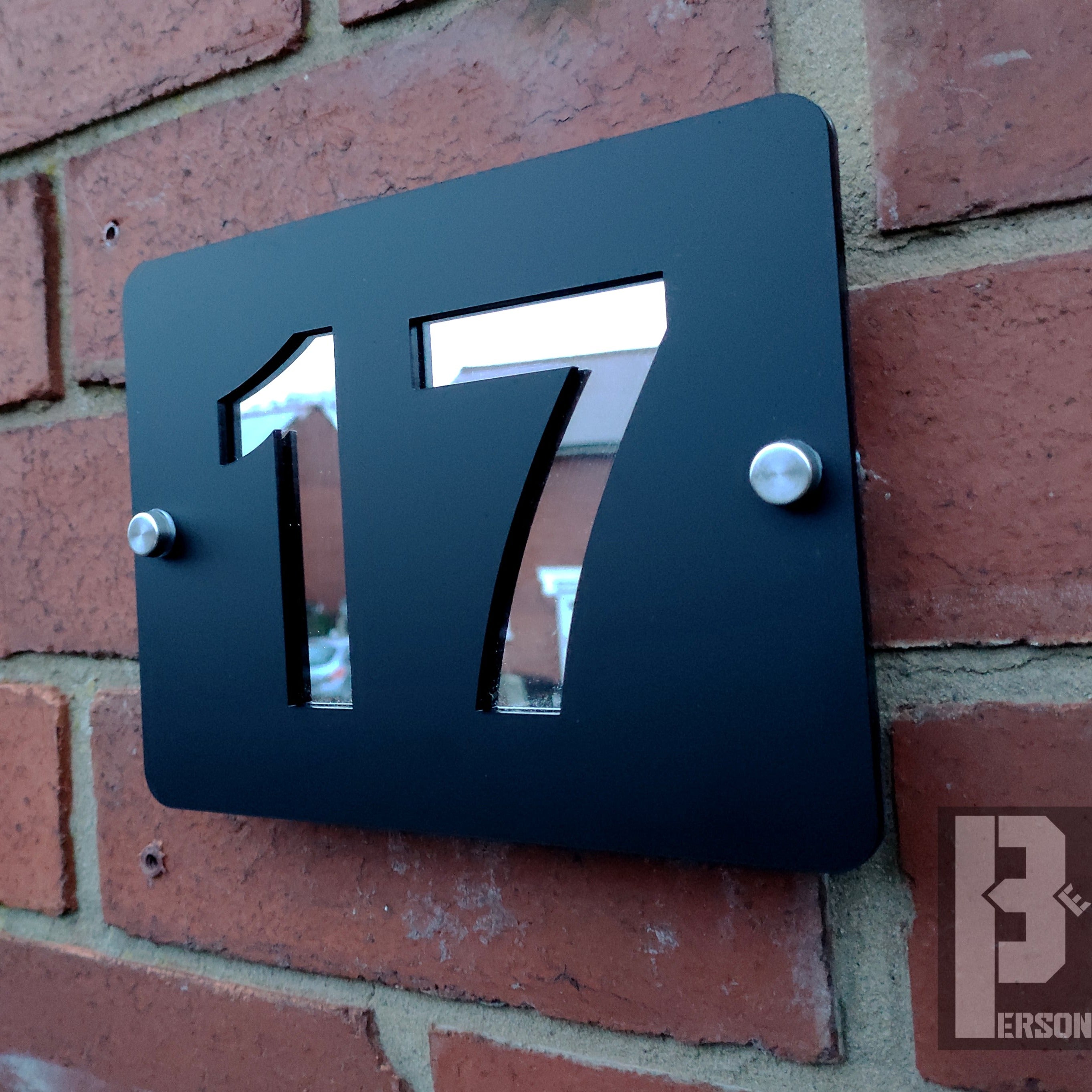 Black mirror door number 17 plaque on brick wall