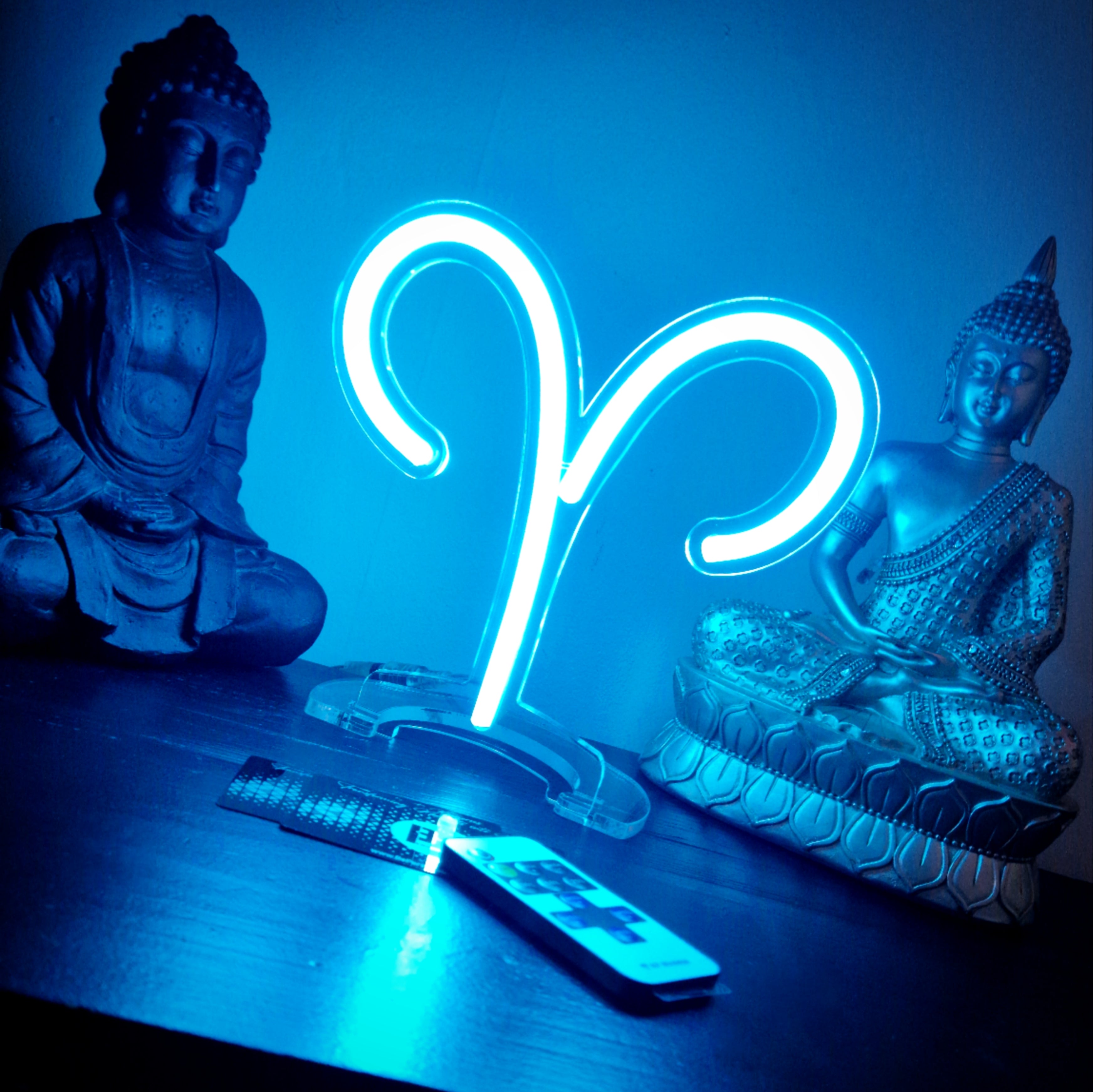 Glowing blue Aries zodiac neon sign on clear acrylic base