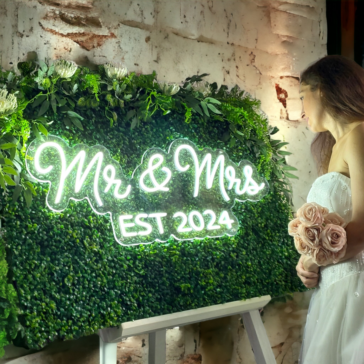 Glowing Mr & Mrs Est 2024 neon sign on green hedge for naughty or nice display